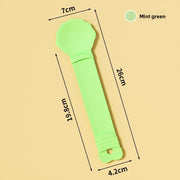 Mint green baby rattle with measurements on a beige background